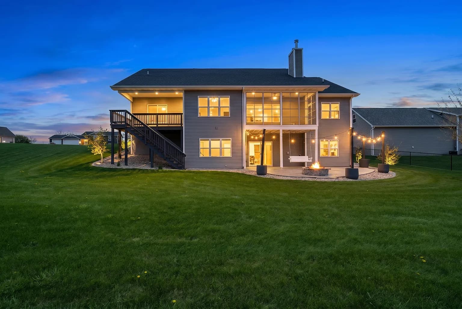 Wisconsin home rear deck and patio lit at dusk
